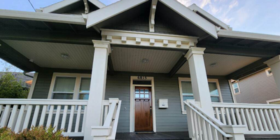 Porch view of a craftsman style green colored home