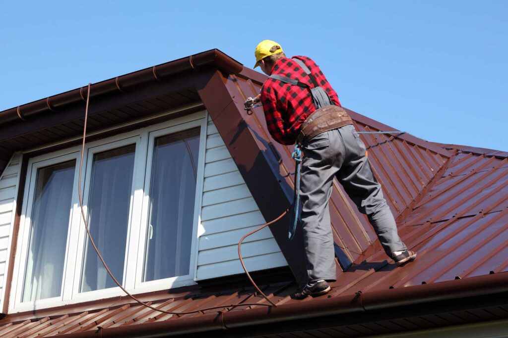 Metal roofing contractor repairing the roof on a second story home